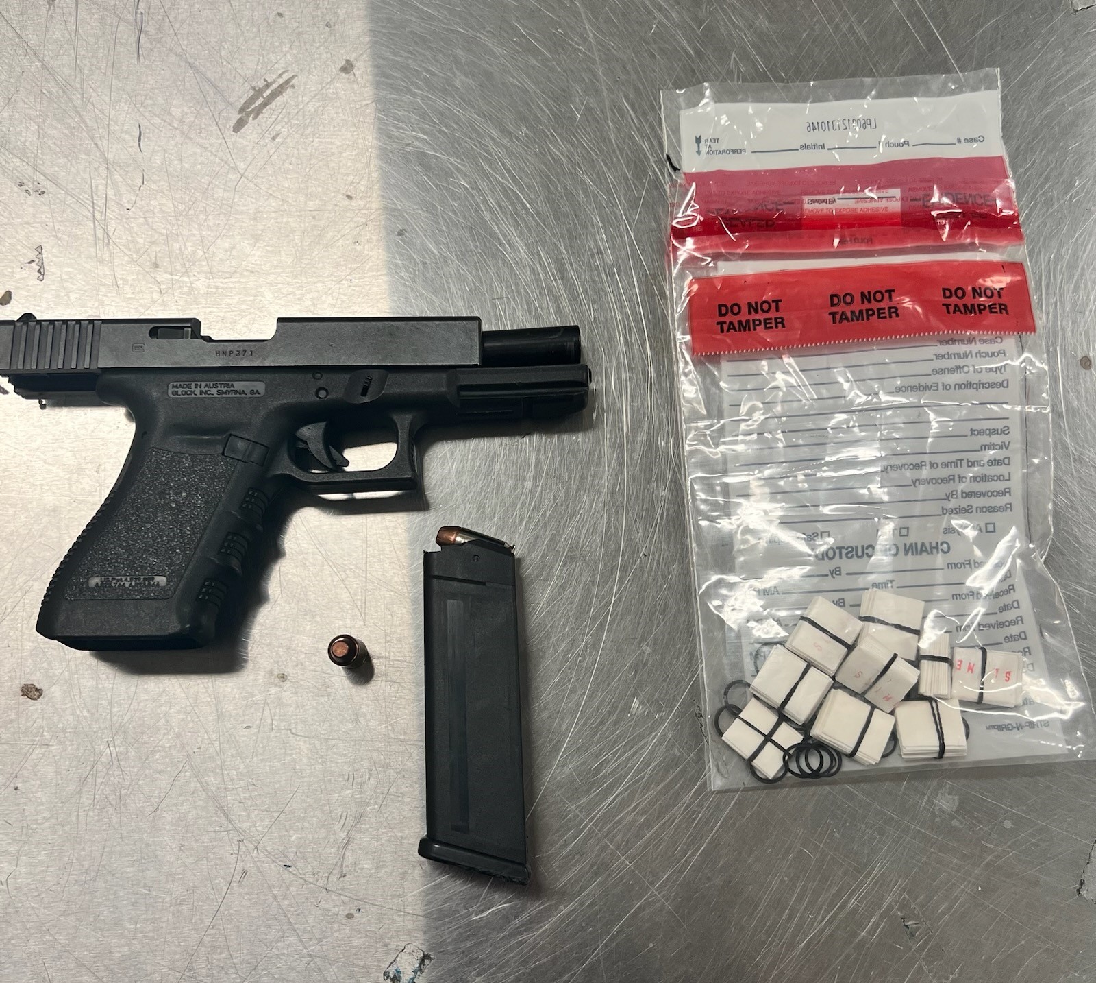 Glock handgun with heroin inside clear evidence bag on metal surface