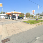 Shell gas station at 3001 New Castle Avenue in New Castle, Delaware, showing a small convenience store, multiple fuel pumps under a canopy, parked vehicles, and roadside signage along a two-lane street during daytime.